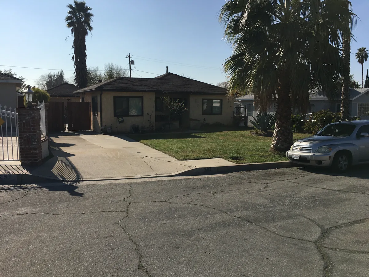 Front exterior of 287 East 43rd Street in San Bernardino, with a lawn and palm trees